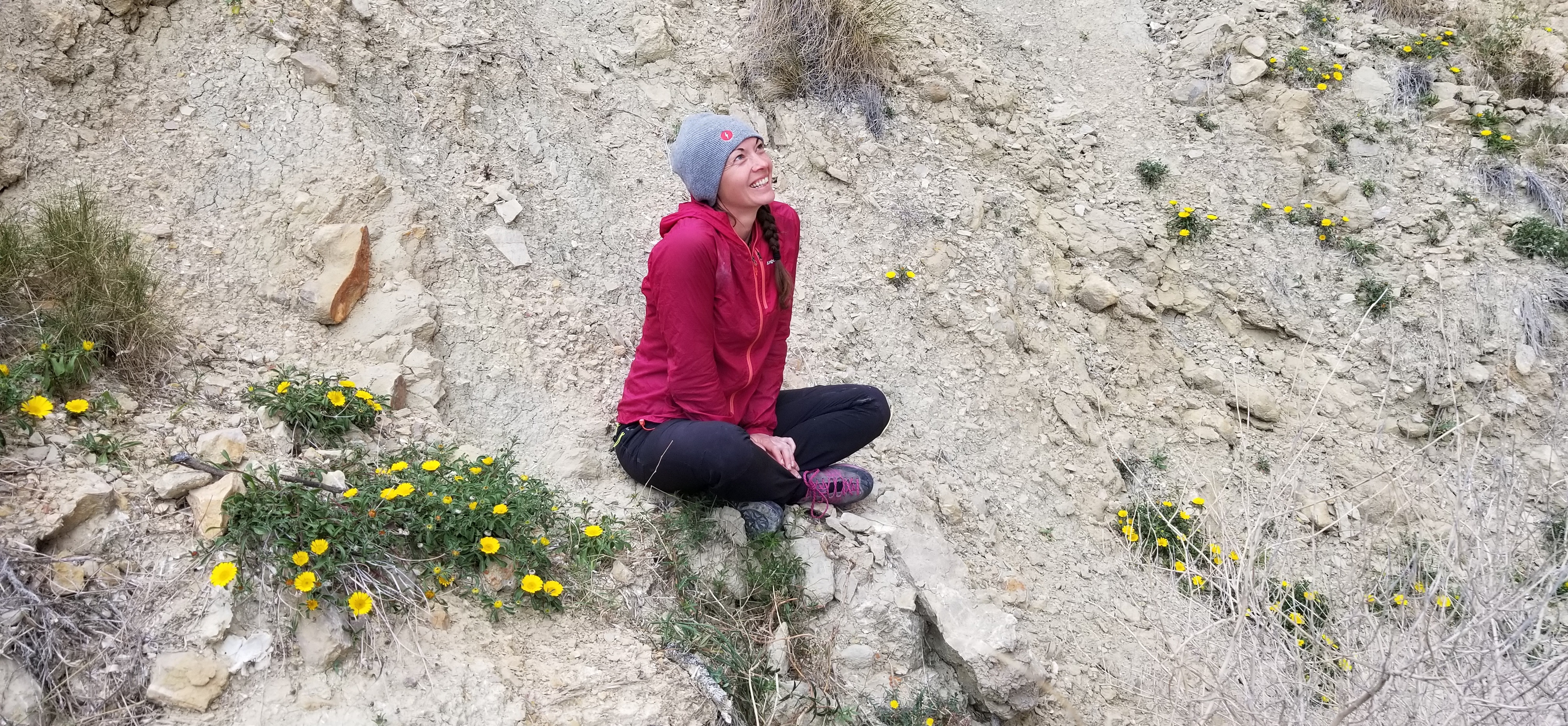 Linda sitting on rocks looking up in beauty